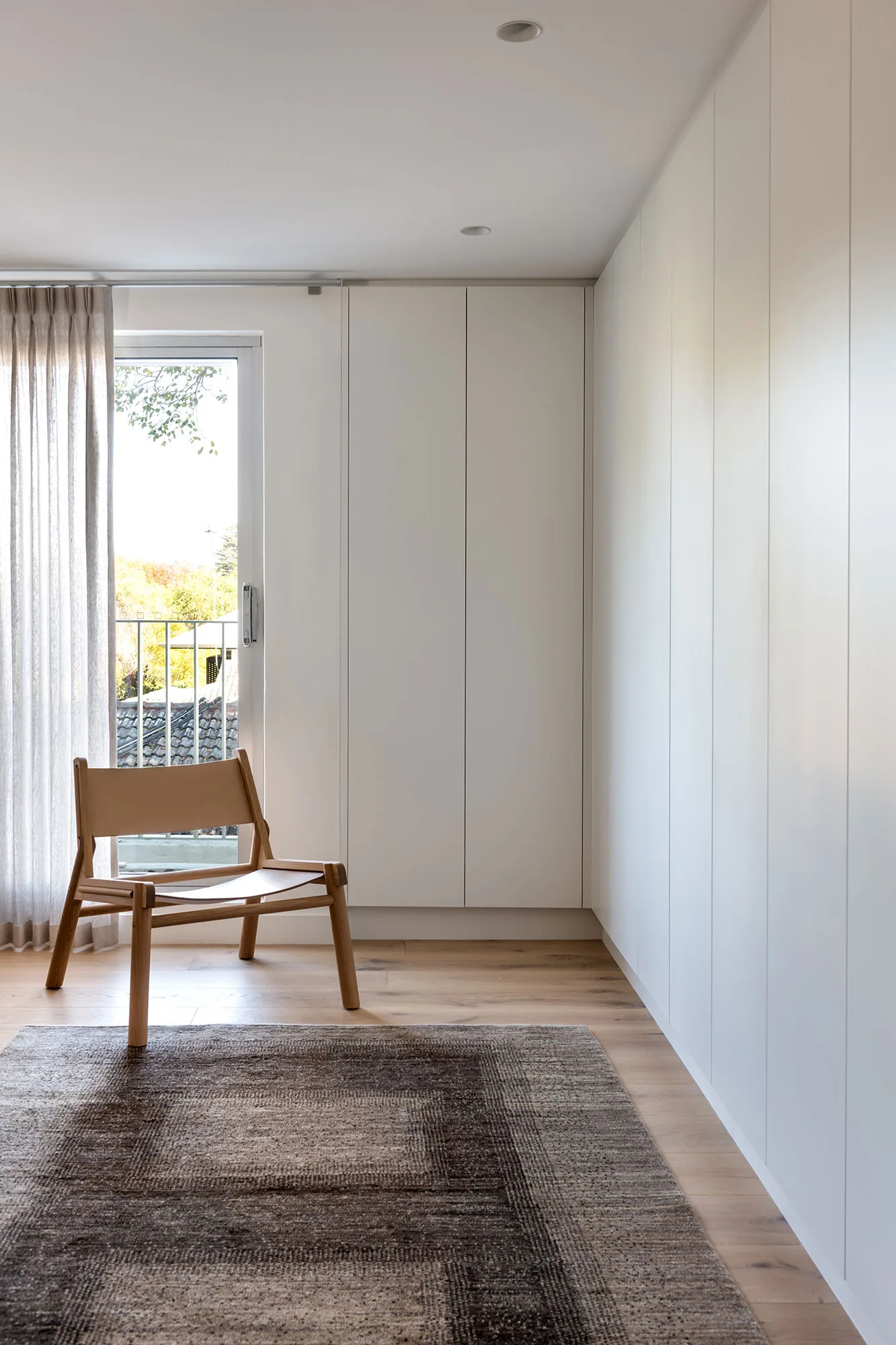 Room by Room Design — full-height white wardrobes with leather sling chair