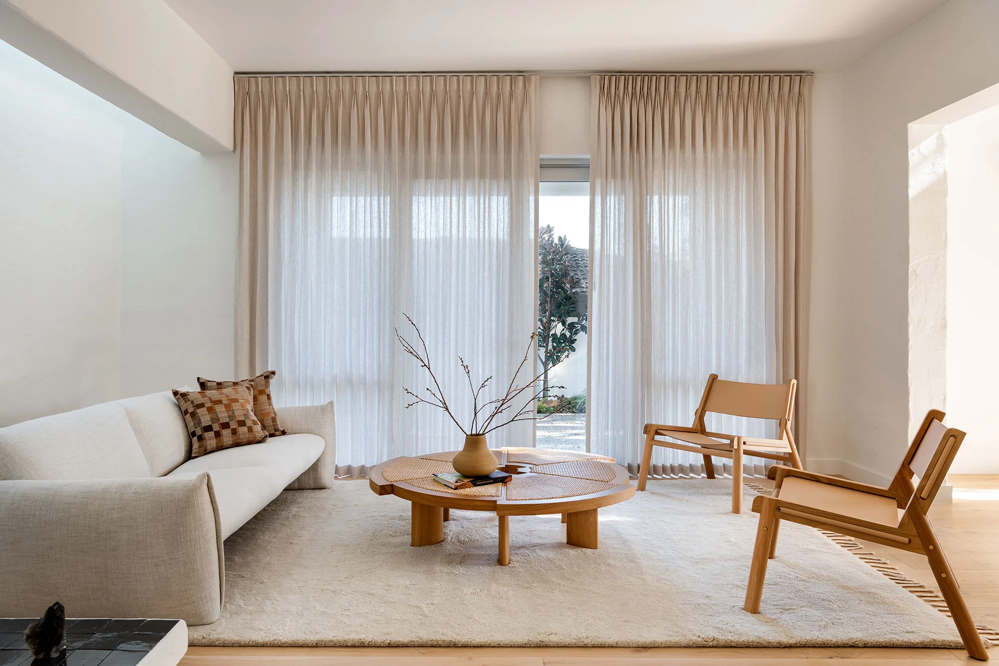 The Refresh — linen sofa with leather sling chairs and round cane coffee table