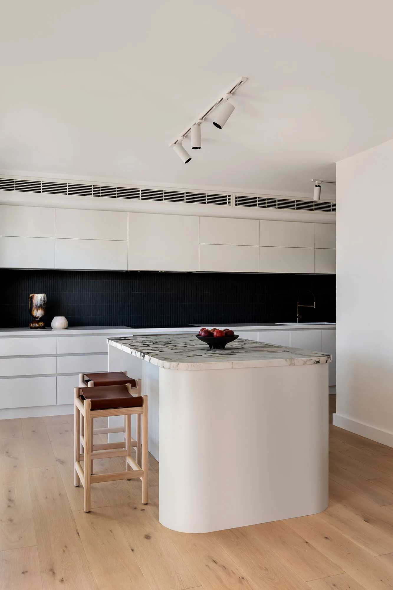 Room by Room Design — kitchen with curved marble island and dark tile splashback