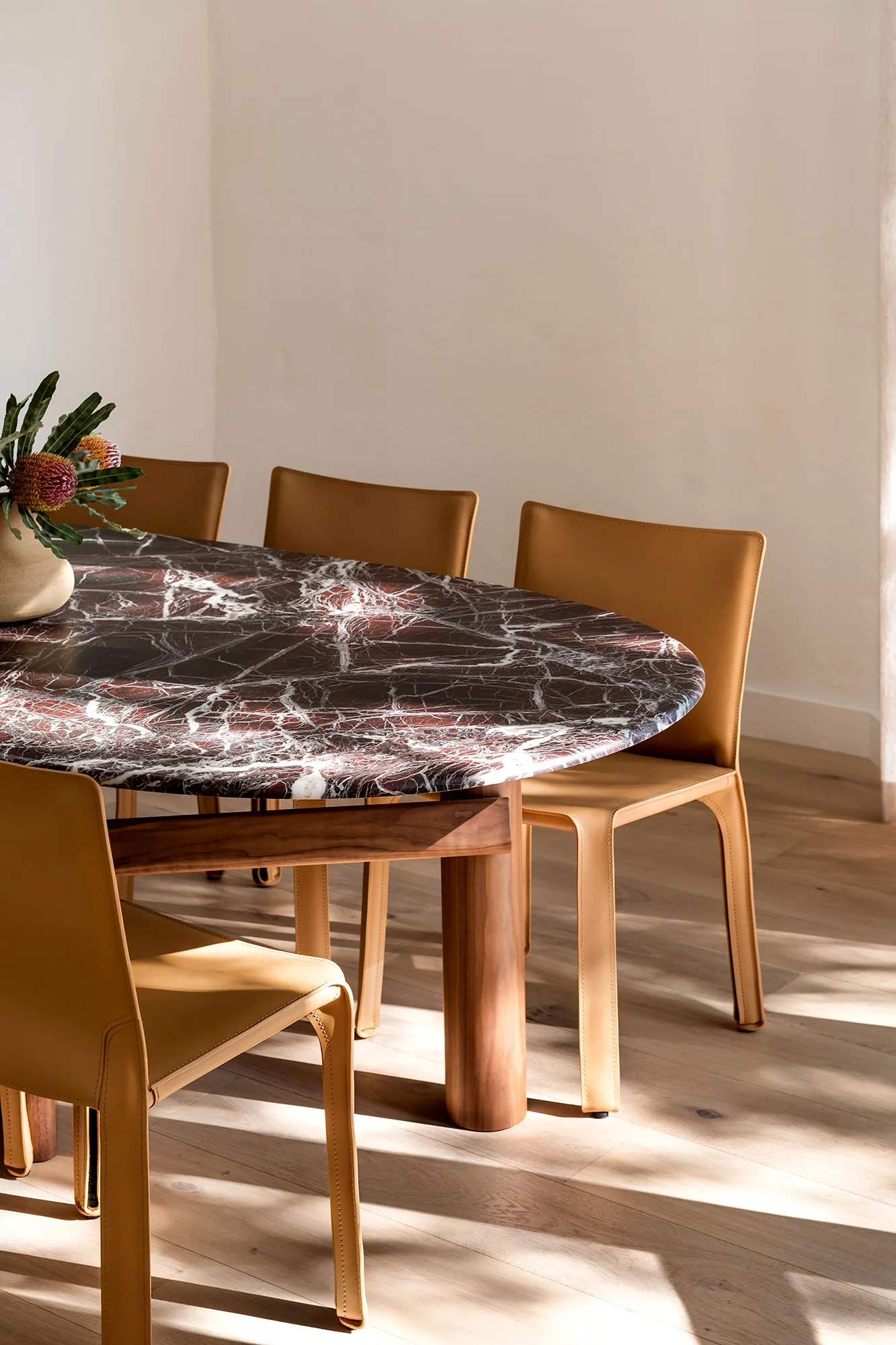 The Refresh — round marble dining table with tan leather chairs