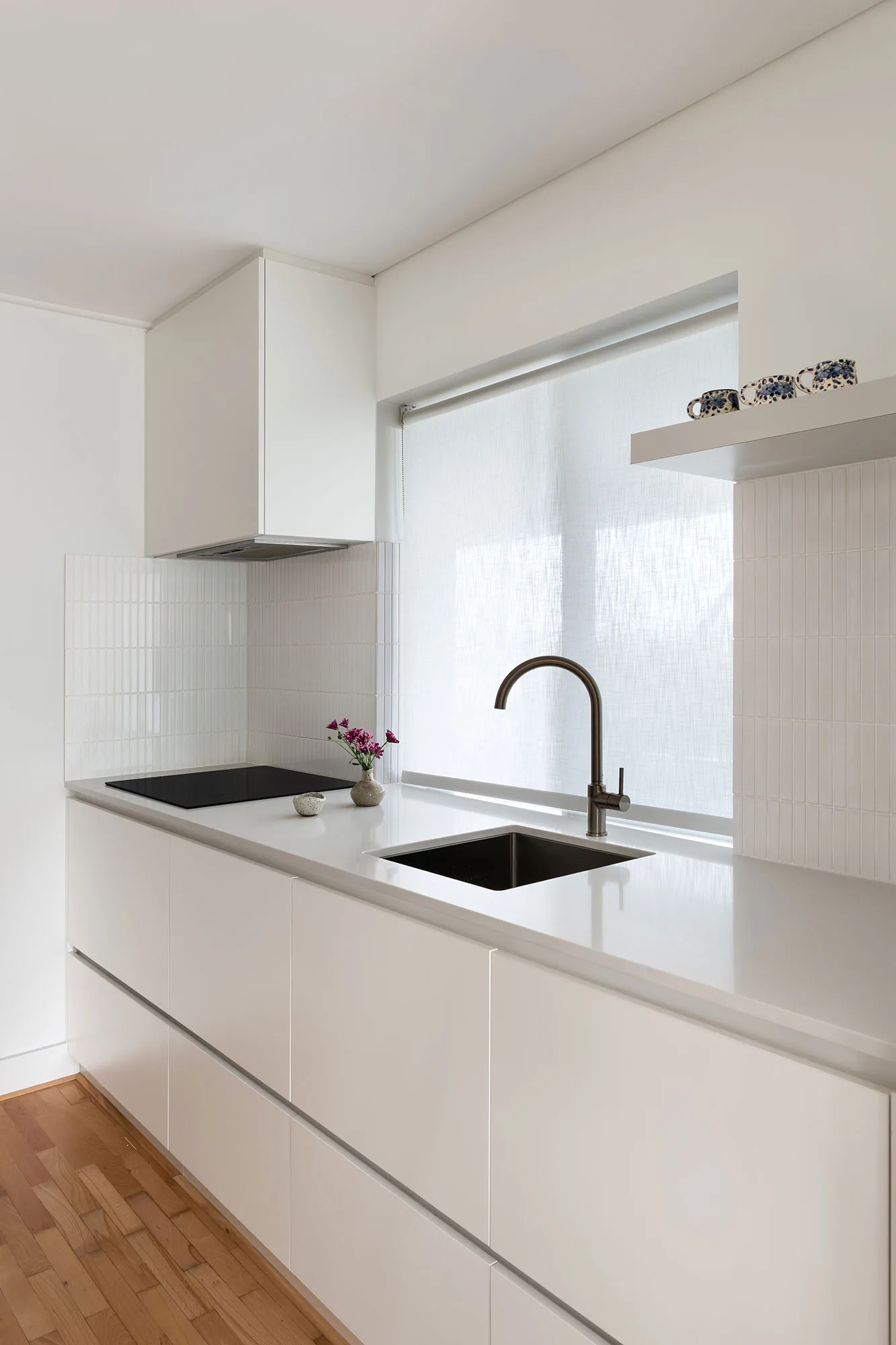 Cottesloe apartment — white kitchen with tiled splashback and brushed tapware