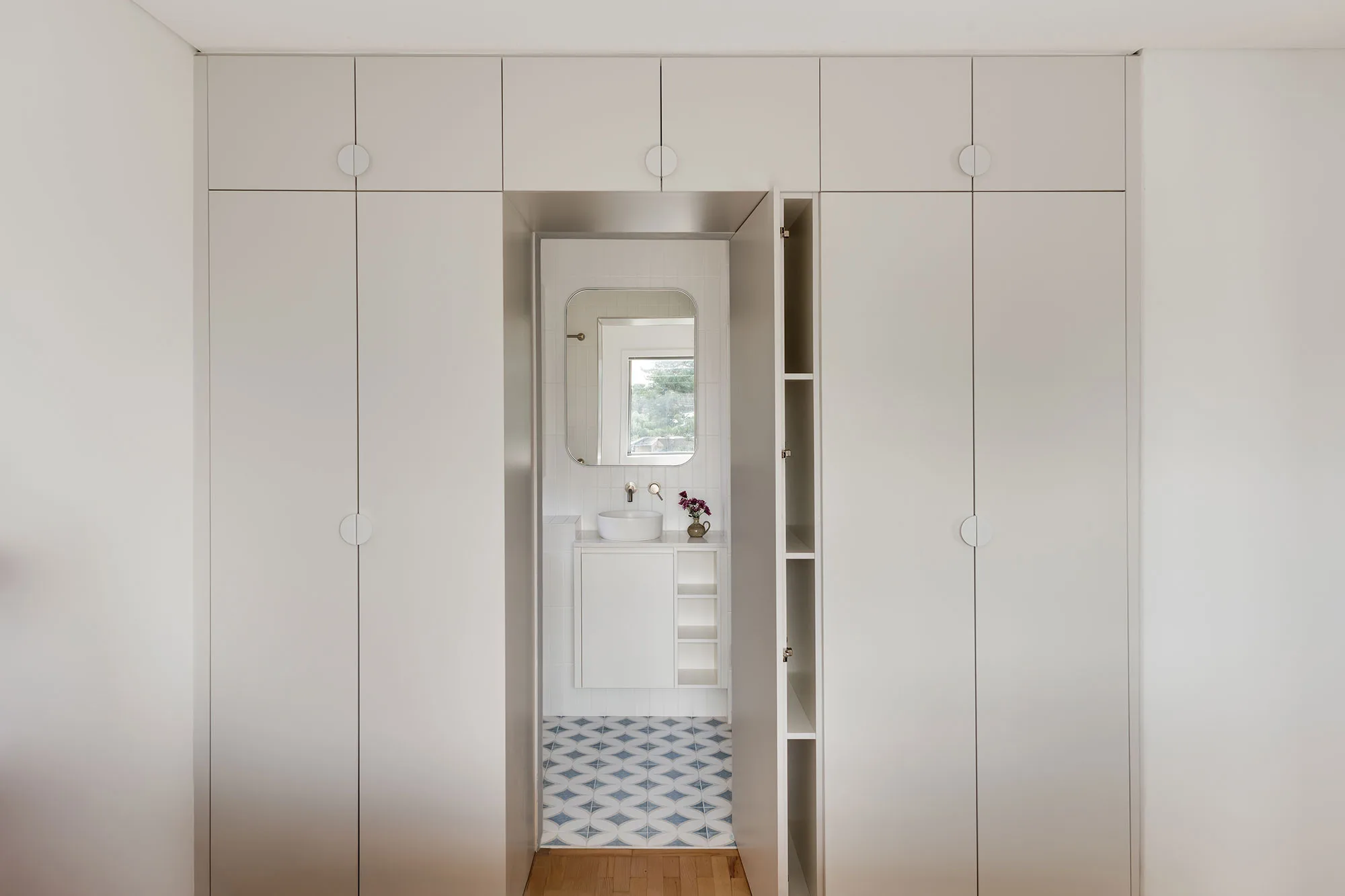 Cottesloe apartment — joinery framing entry to patterned-tile bathroom