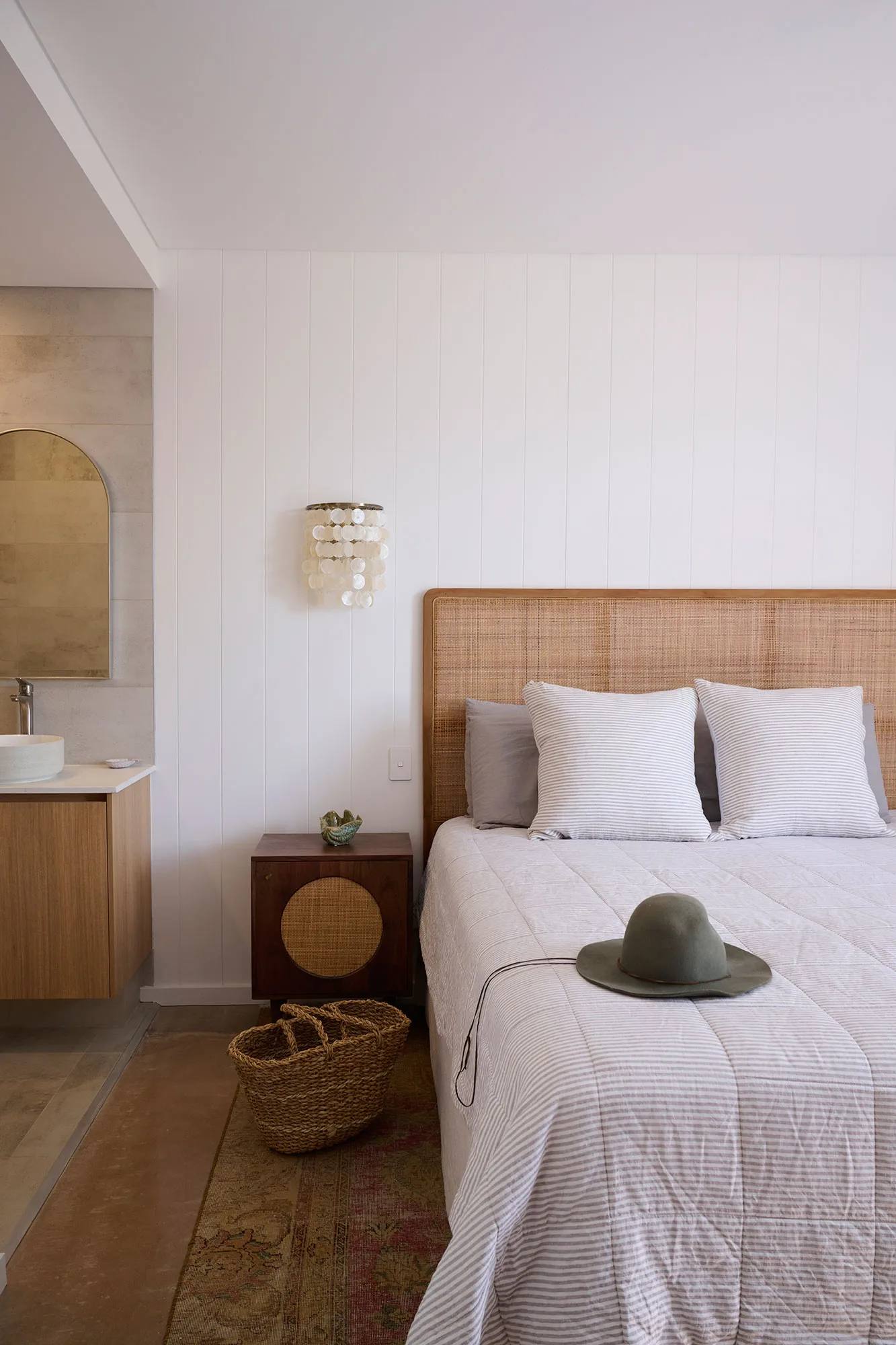 Exmouth I home — bedroom with cane bedhead, striped linen and capiz shell sconce