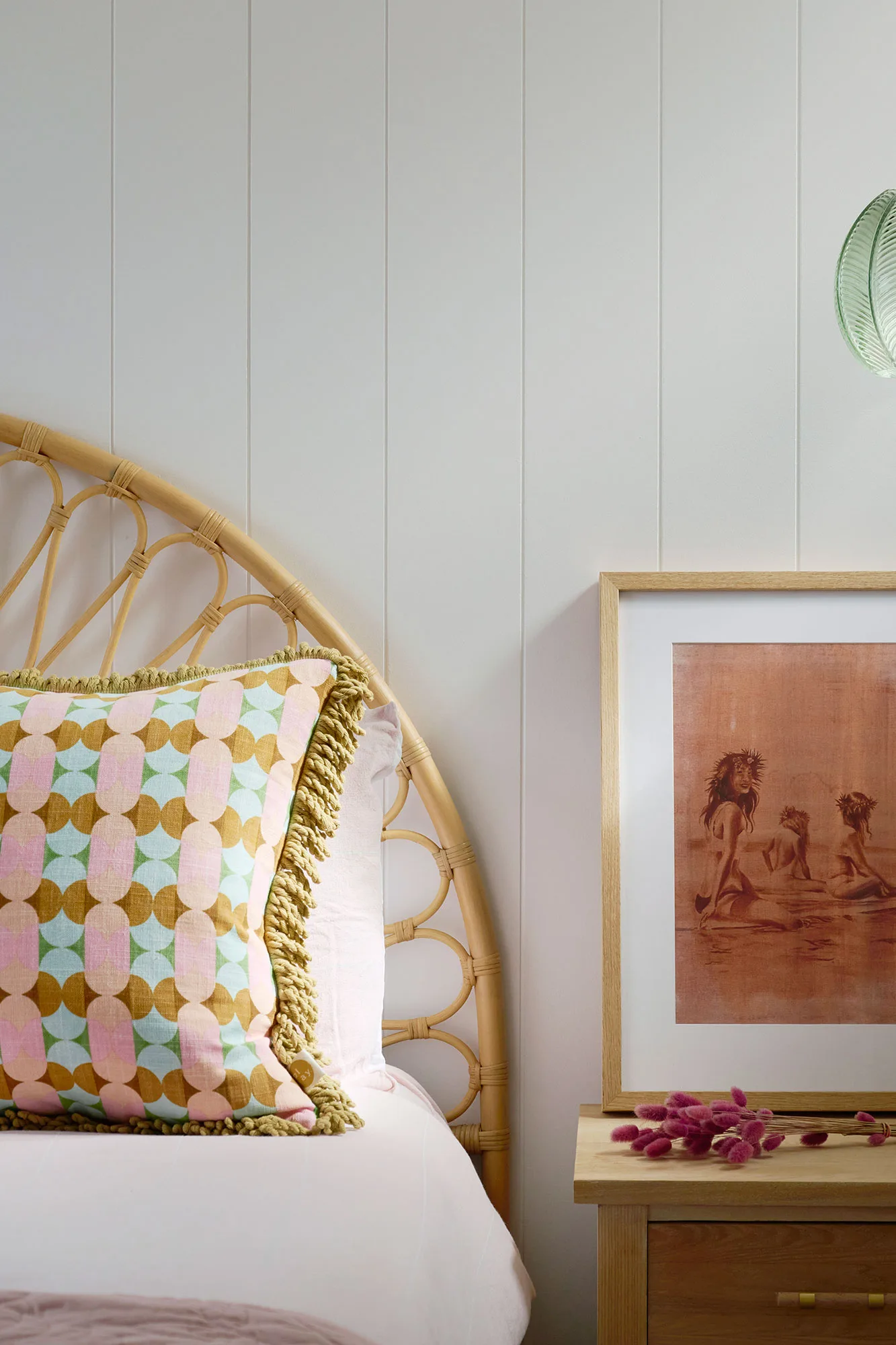 Exmouth I home — bedroom with arched rattan headboard, geometric cushion and vintage artwork