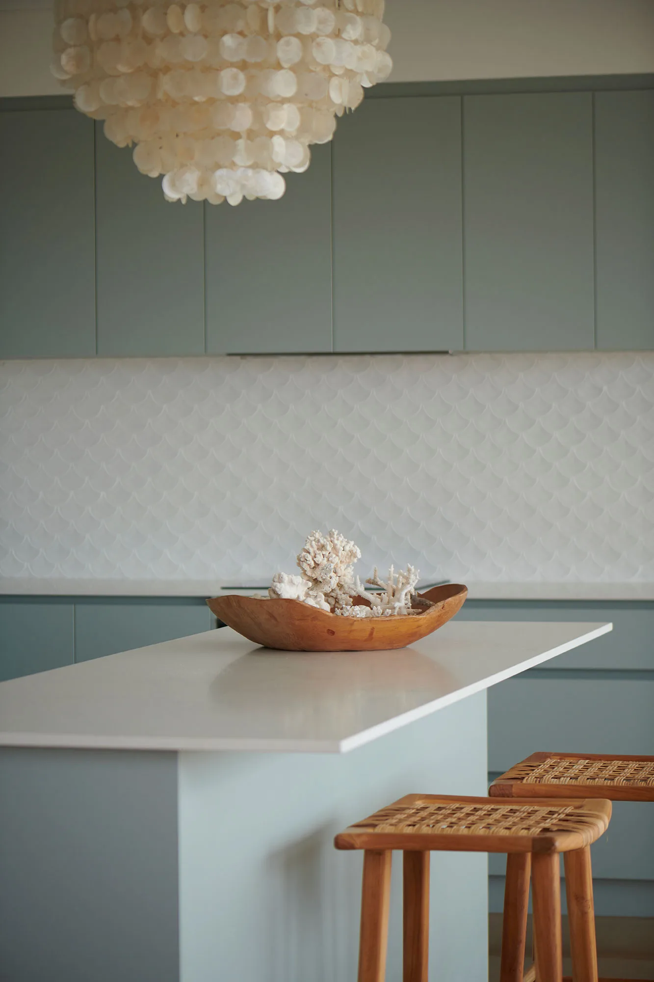 Exmouth I home — kitchen island with capiz pendant, scalloped splashback and coral display